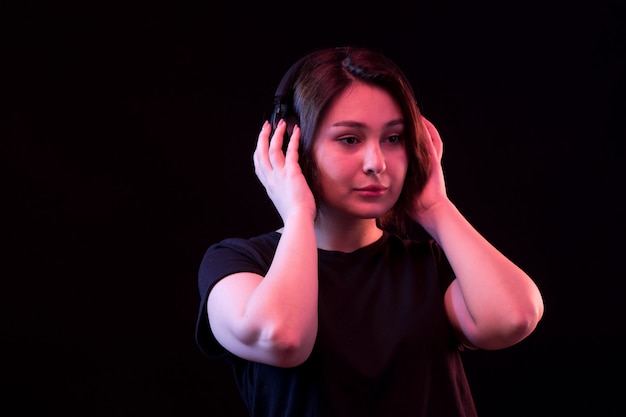 Free photo young woman with black t-shirt using headphones