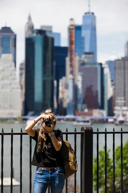 Free Photo young woman with blurred city background