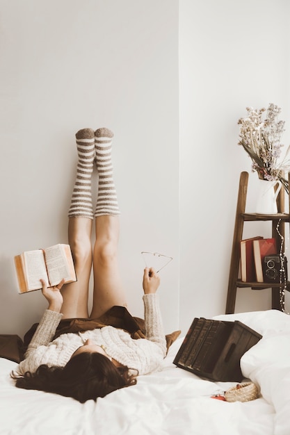 Free Photo young woman with book relaxing near wall