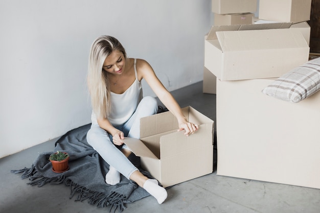 Free photo young woman with boxes on the floor