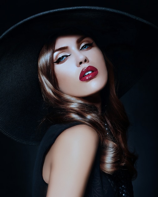 Young woman with bright makeup and black hat