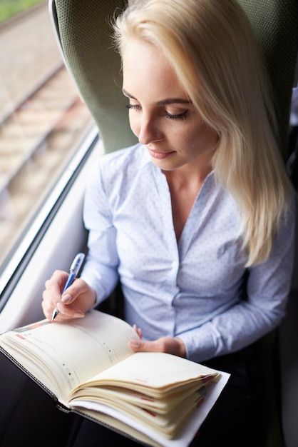 Free photo young woman with calendar traveling by train