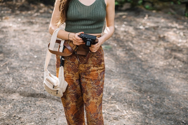 Free photo young woman with a camera in nature