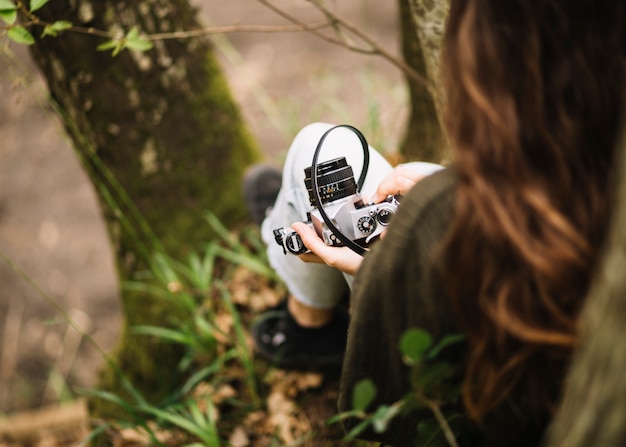 Free photo young woman with a camera in nature