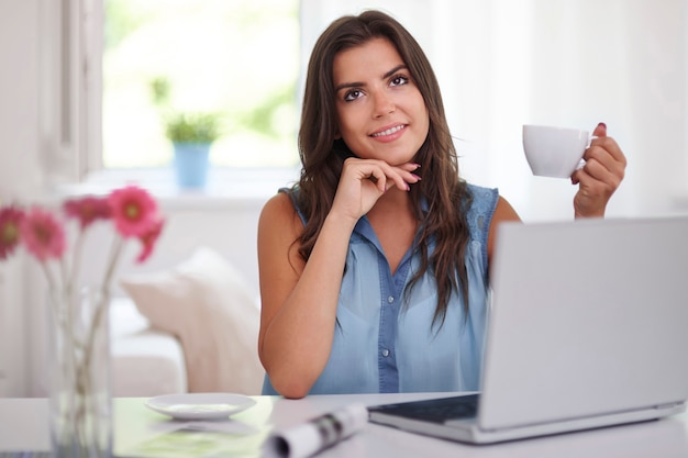 Young woman with coffee cup and laptop computer