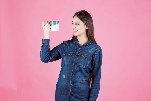 Free photo young woman with a coffee cup smiling and feeling positive