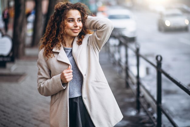 Young woman with curly hair outside the street