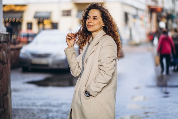 Free photo young woman with curly hair outside the street