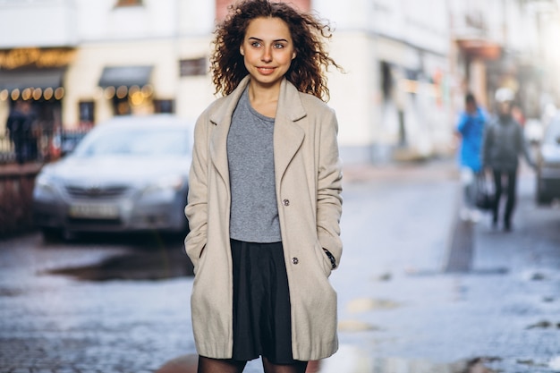 Free photo young woman with curly hair outside the street