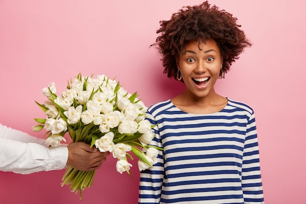 Free photo young woman with curly hair receiving bouquet of white flowers