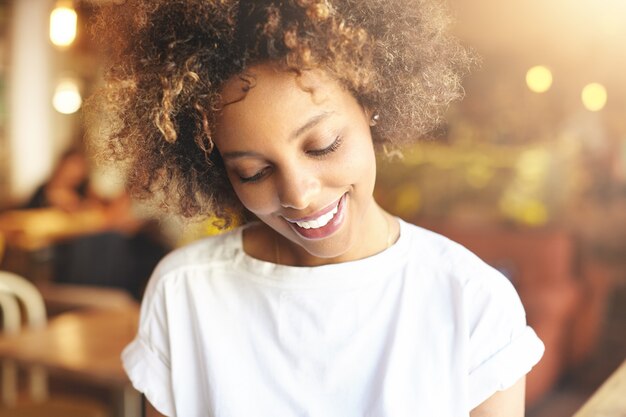 Young woman with curly hair sitting in cafe