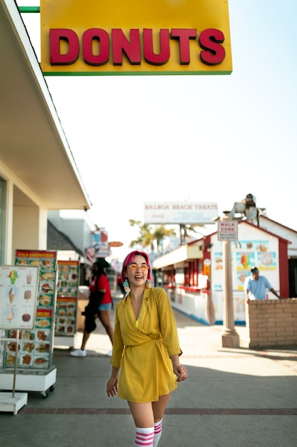 Free photo young woman with dyed hair near shop