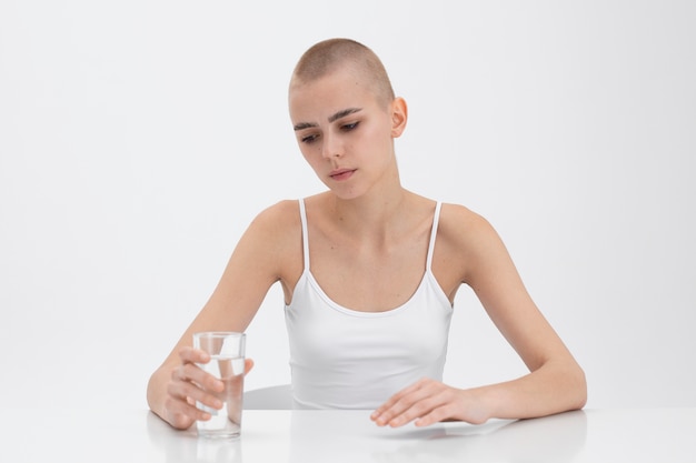 Young woman with an eating disorder looking at a glass of water