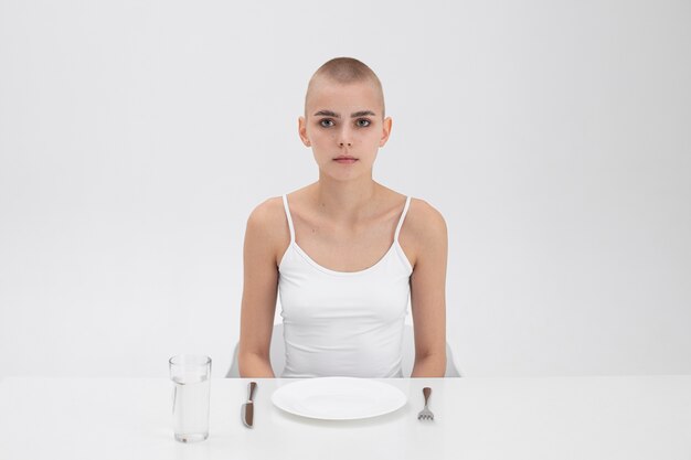 Young woman with an eating disorder sitting at the table