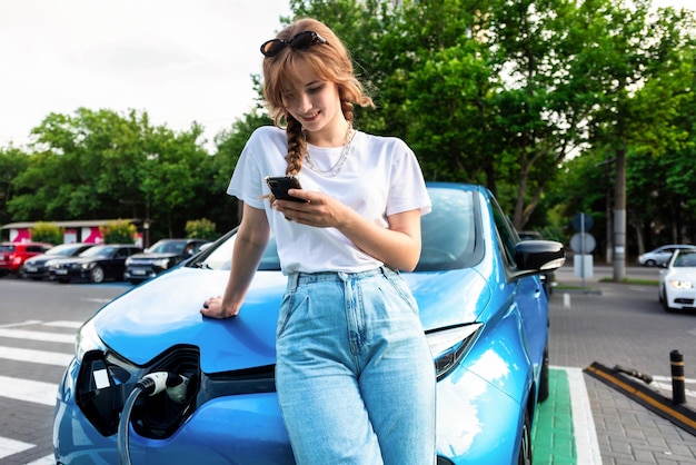 Free photo young woman with an electric car at charging station in chisinau moldova