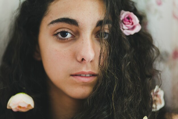 Young woman with flowers in hair looking at camera