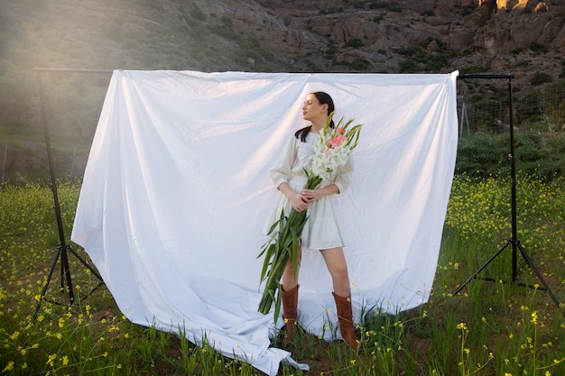 Young woman with gladiolus in nature