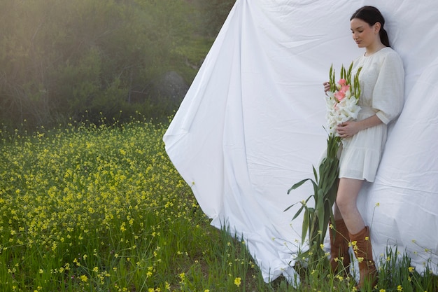 Free Photo young woman with gladiolus in nature