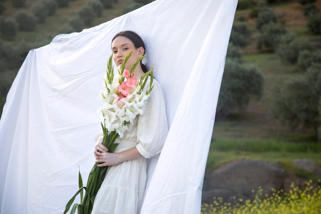 Free photo young woman with gladiolus in nature