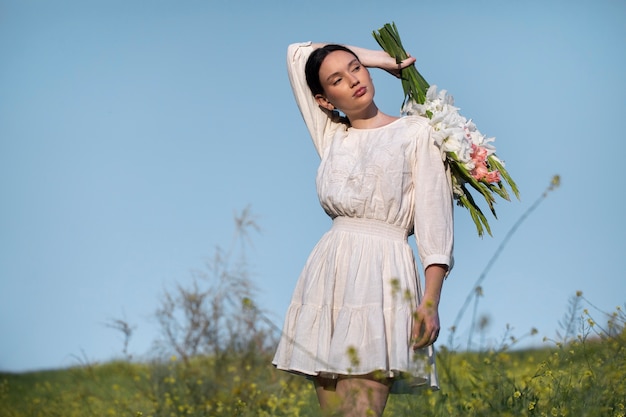 Young woman with gladiolus in nature