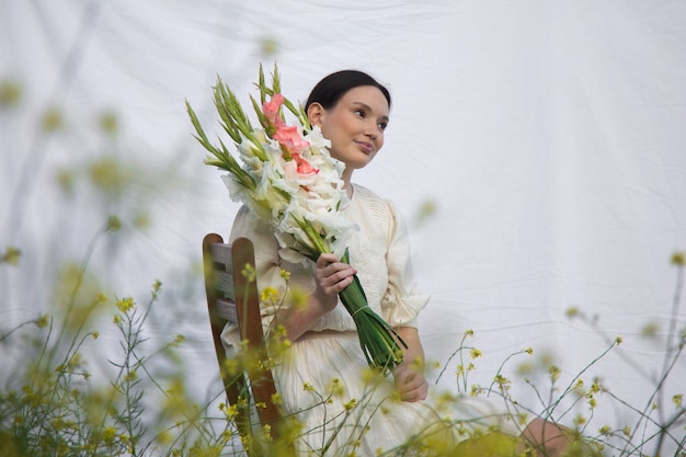 Young woman with gladiolus in nature