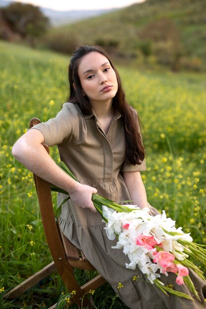 Young woman with gladiolus in nature