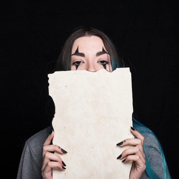 Young woman with Halloween makeup holding piece of paper