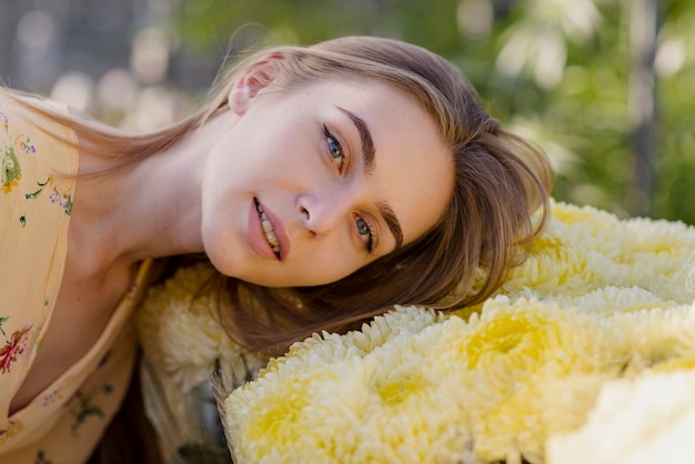 Free photo young woman with head on flowers