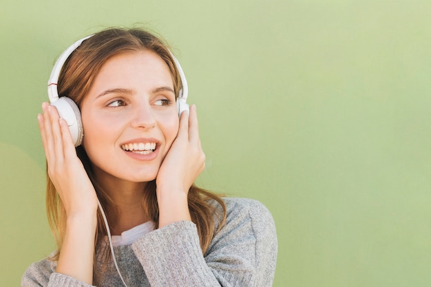 Young woman with headphone on her head listening music