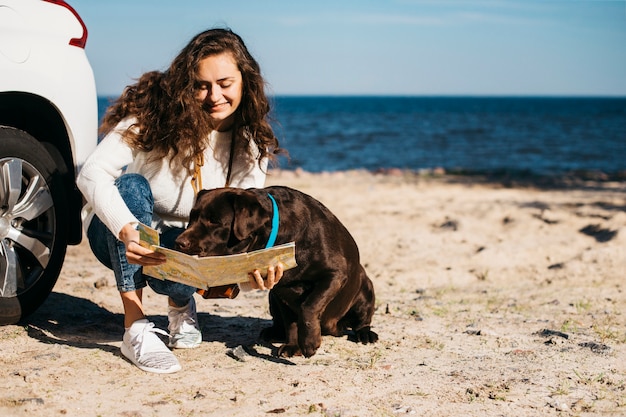 Free photo young woman with her dog at the beach