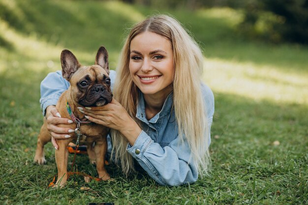 Young woman with her pet french bulldog in park