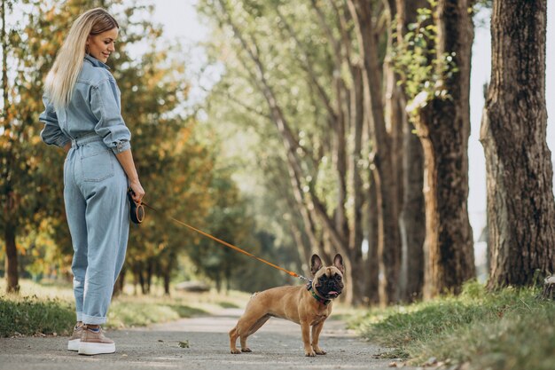 Young woman with her pet french bulldog in park