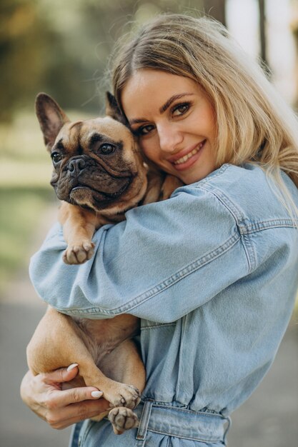 Young woman with her pet french bulldog in park