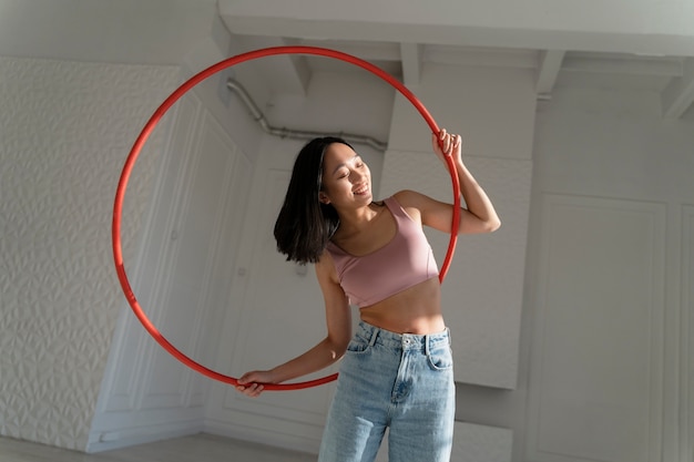 Free photo young woman with hula hoop