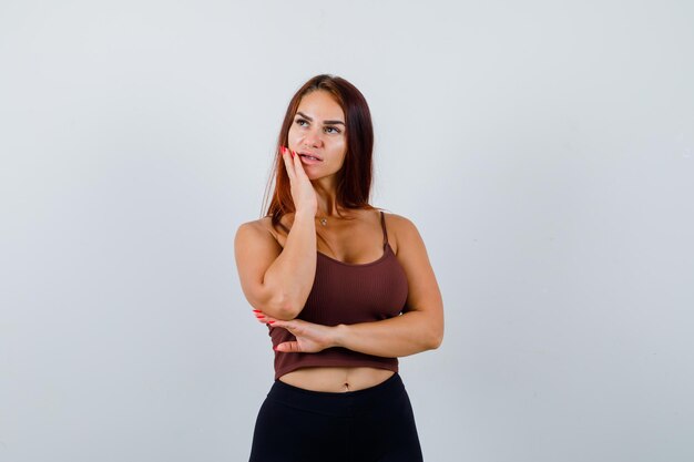 Young woman with long hair in a brown crop top