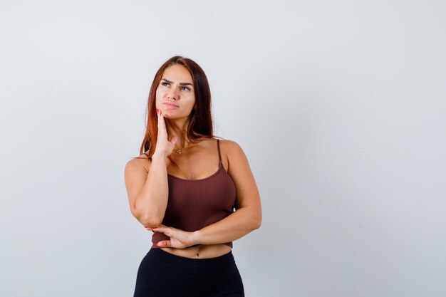 Young woman with long hair in a brown crop top