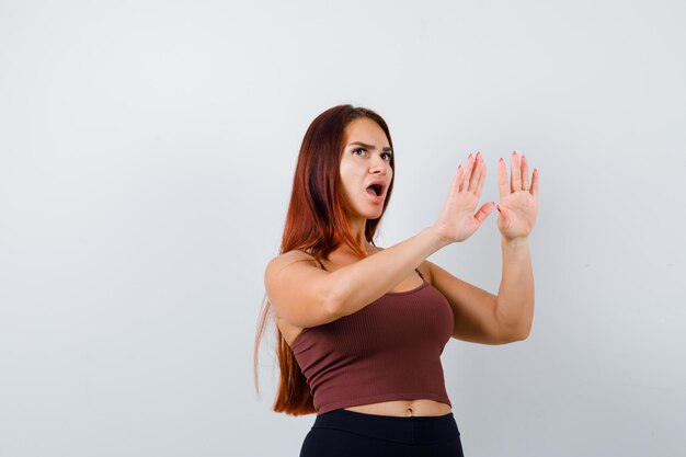 Young woman with long hair in a brown crop top