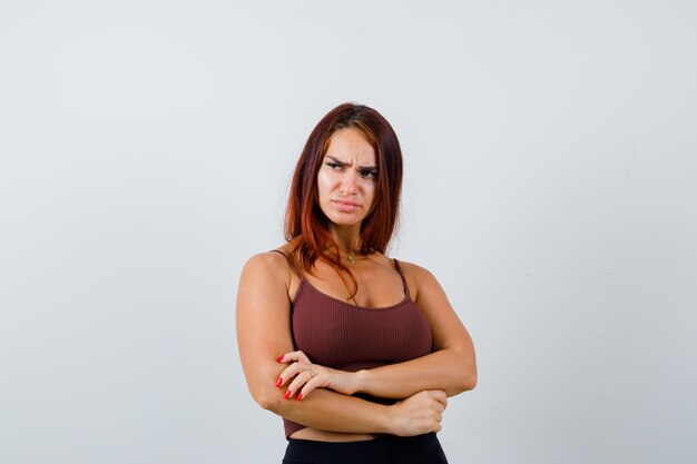 Young woman with long hair in a brown crop top