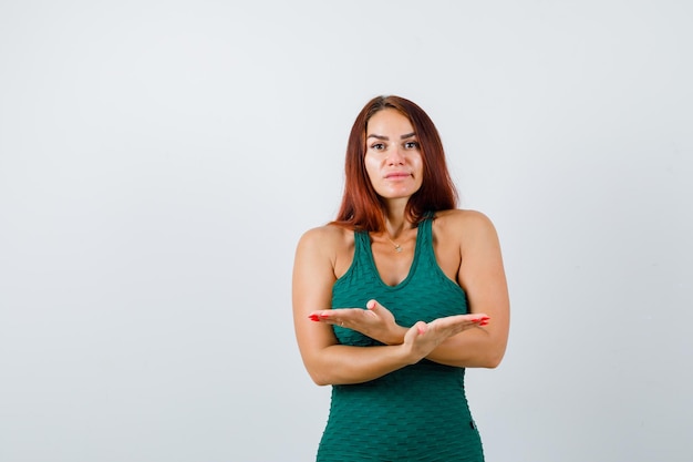 Free photo young woman with long hair wearing a green bodycon