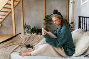 Free photo young woman with messy bun working from home