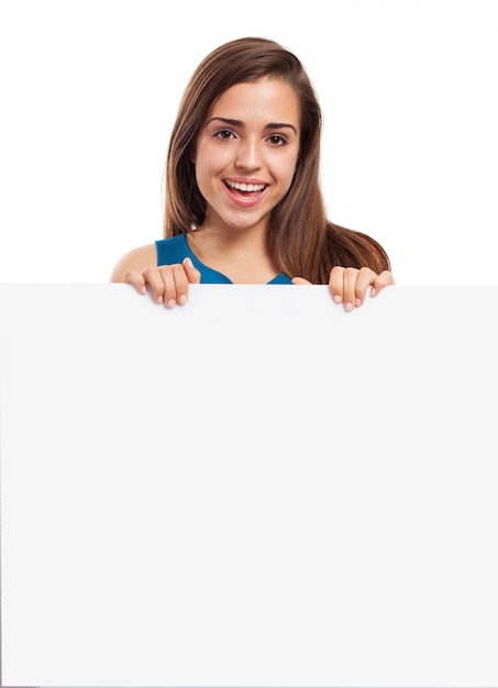 Young woman with a nice smile posing with an empty poster