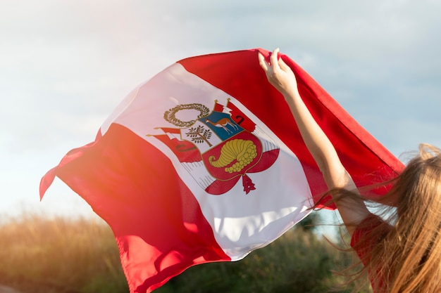 Young woman with peru flag outdoors