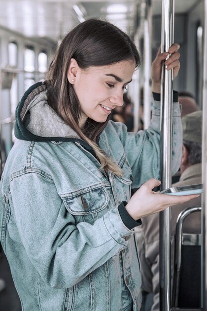 Young woman with phone in public transport