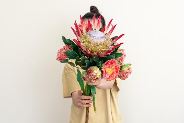 A young woman with protea flower on a white background