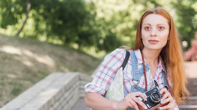 Young woman with retro camera in park