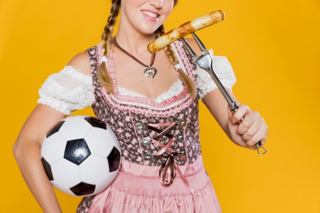 Free photo young woman with sausage and ball