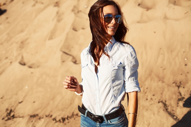 Young woman with shirt and jeans on the beach