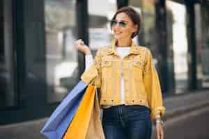 Free photo young woman with shopping bags in the city