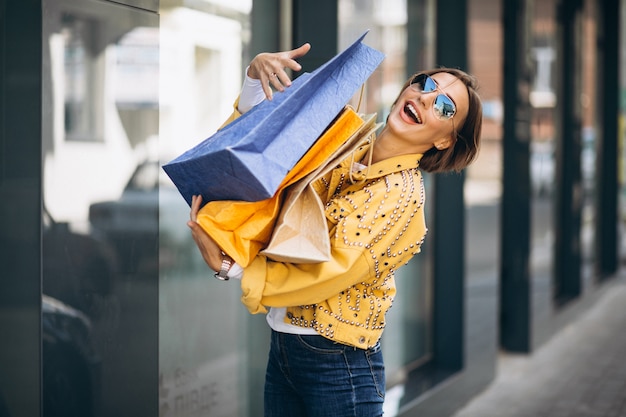 Free Photo young woman with shopping bags in the city