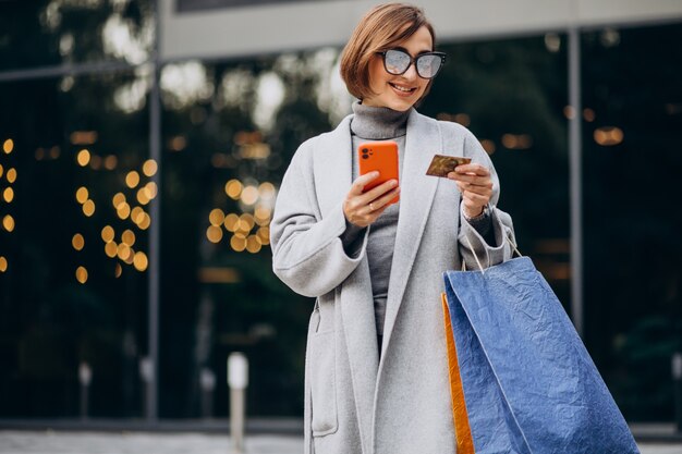 Young woman with shopping bags talking on the phone